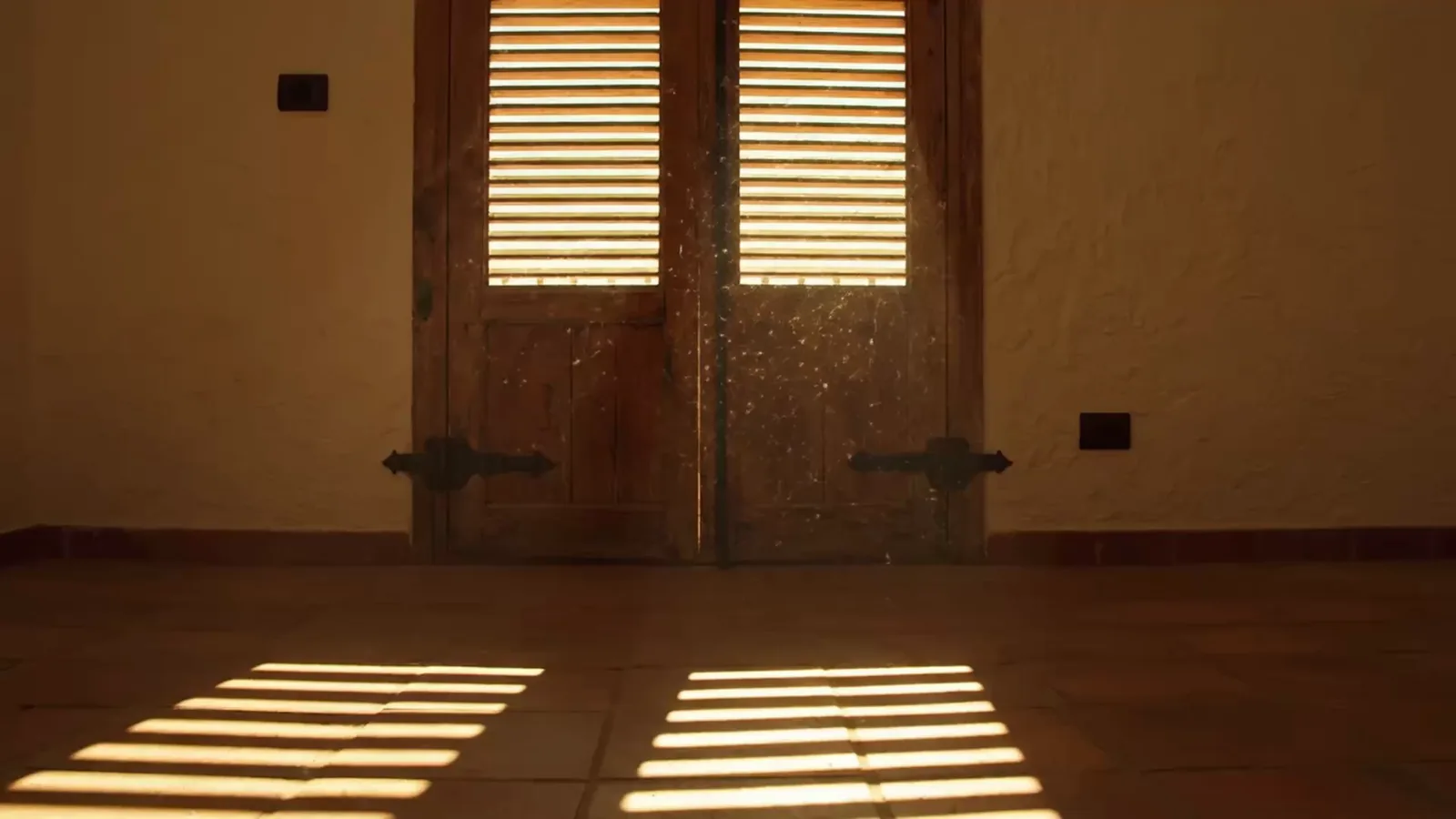 Shuttered Mediterranean apartment in Torrevieja, sunlight falling across the terracotta floor